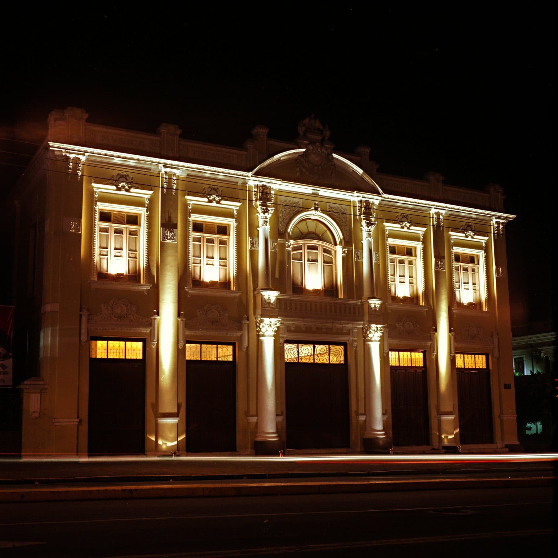 A fachada eclética voltada para a Praça da Catedral, com eixo central destacado e inscrições ligadas à música e ao drama.